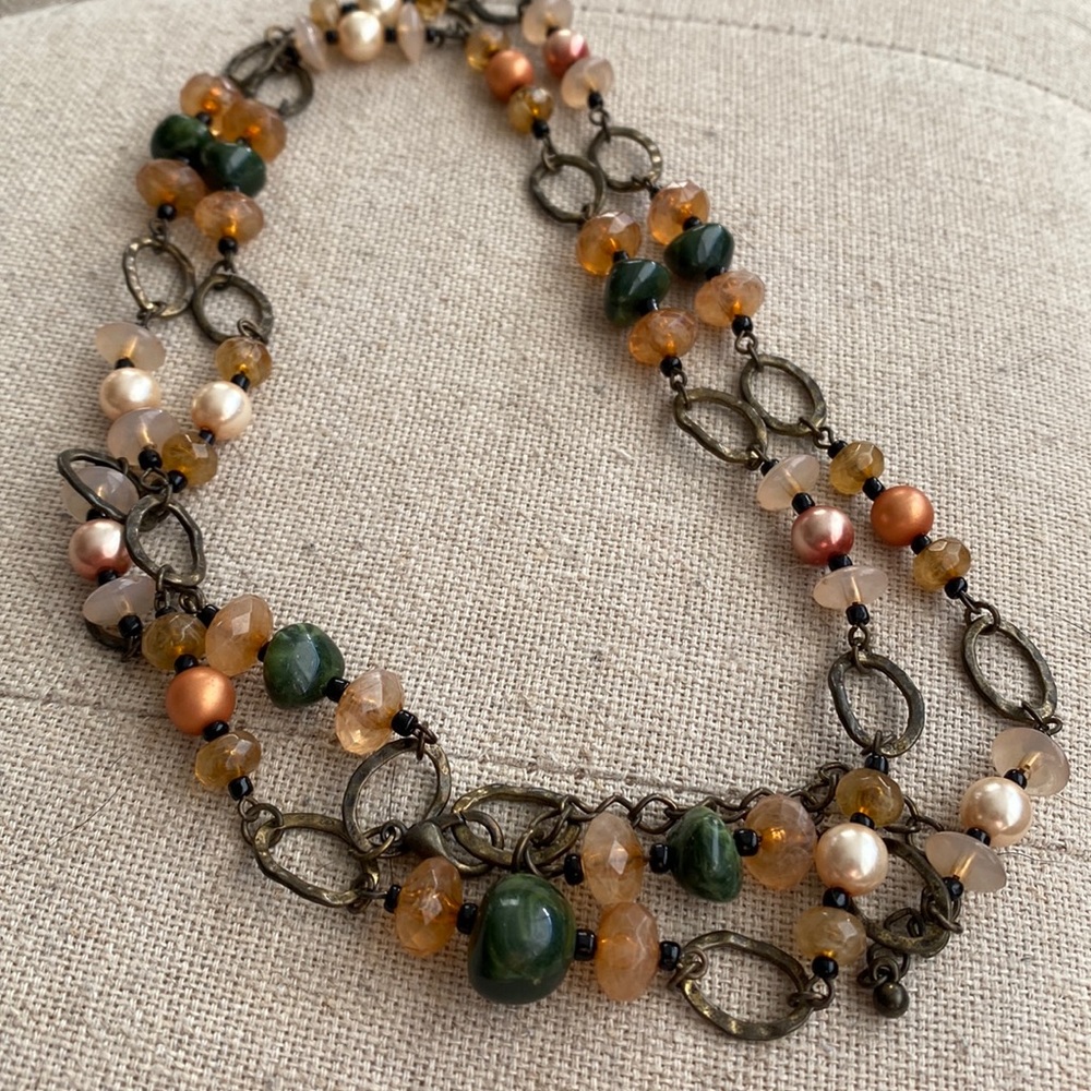 Metal and beaded necklace in shades of bronze and peachy orange.
